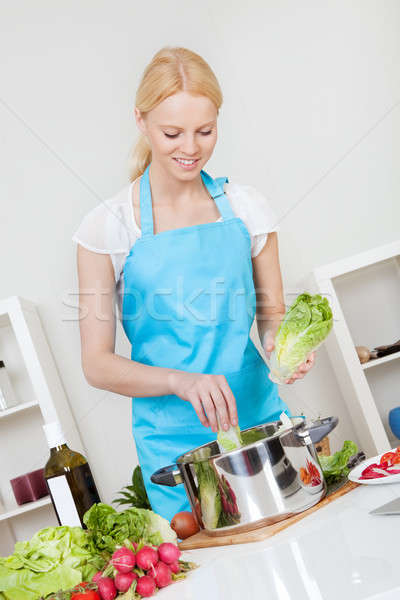 Cheerful young woman cooking Stock photo © AndreyPopov
