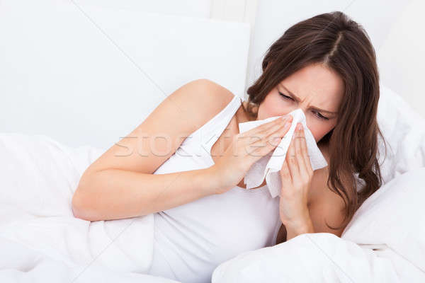 Młoda kobieta grypa bed zakażony alergia dmuchanie nosa Zdjęcia stock © AndreyPopov