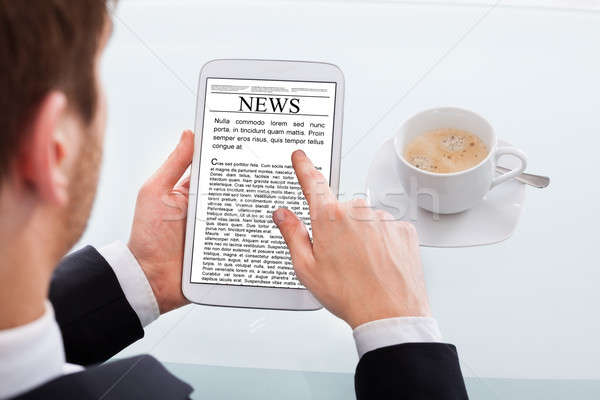 Empresario lectura noticias digital tableta escritorio Foto stock © AndreyPopov
