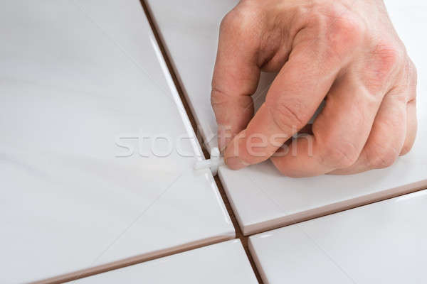 Person's Hand Placing Spacers Between Tiles Stock photo © AndreyPopov