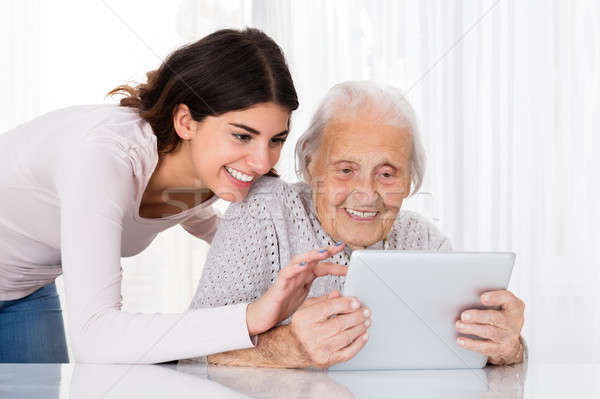 Two Happy Women Using Digital Tablet Stock photo © AndreyPopov