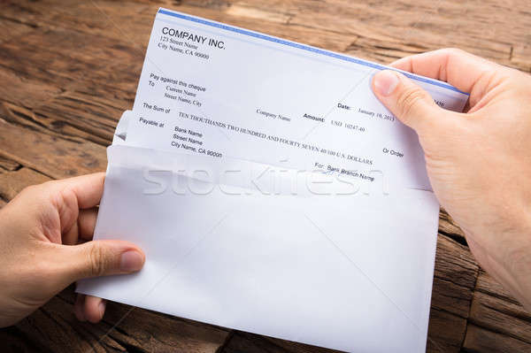 Businessman's Hands Holding Cheque At Table Stock photo © AndreyPopov