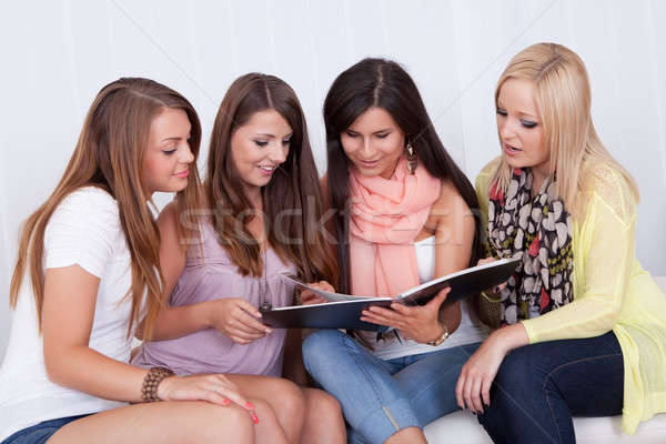 Four female friends looking at a folder Stock photo © AndreyPopov