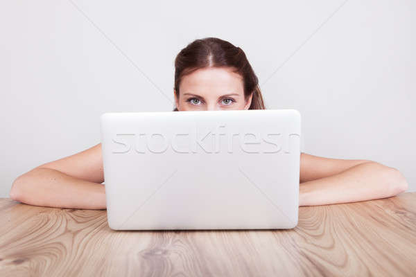 Woman hiding behind her laptop Stock photo © AndreyPopov