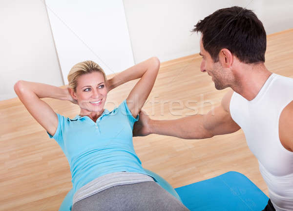 Stock photo: Fitness instructor teaching sit ups