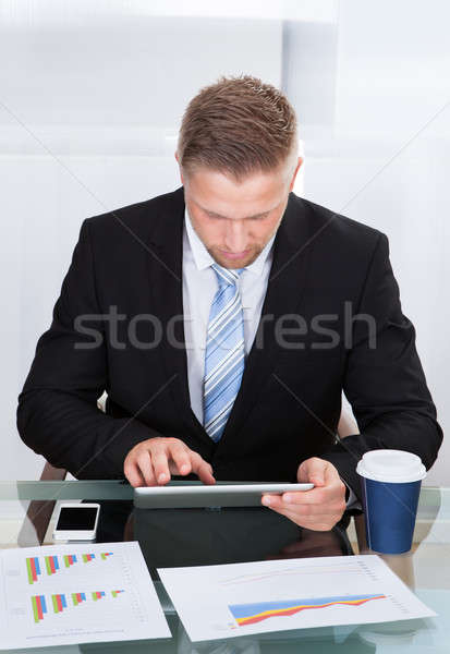 Stylish hardworking businessman using a tablet computer Stock photo © AndreyPopov