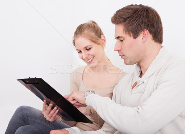 Young Happy Couple Holding Clipboard Stock photo © AndreyPopov