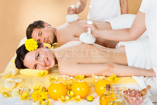 Couple Receiving Massage With Herbal Compress Stamps At Spa Stock photo © AndreyPopov