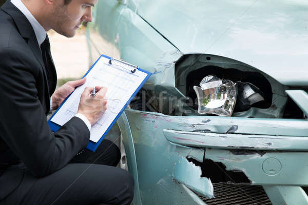 Seguro agente examinar coche accidente vista lateral Foto stock © AndreyPopov