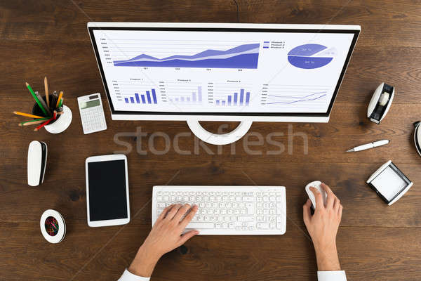 Businessperson Analyzing Statistical Graph On Computer Stock photo © AndreyPopov