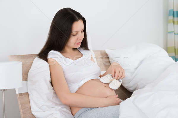 Expecting Woman Holding Small Shoes Stock photo © AndreyPopov