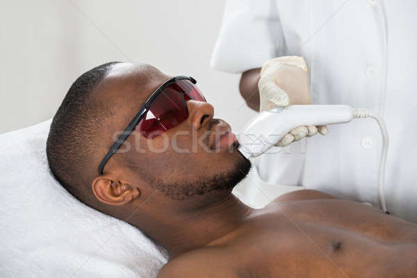 Therapist Giving Laser Epilation Treatment On Young Man Stock photo © AndreyPopov