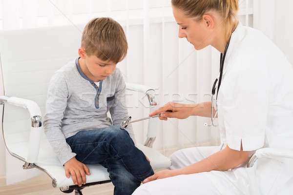 Doctor Checking Knee Reflex On Child Patient Stock photo © AndreyPopov
