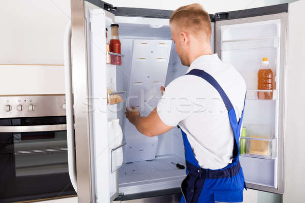 Festsetzung Kühlschrank jungen männlich Küche Stock foto © AndreyPopov