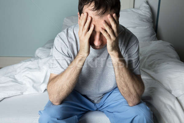 Stressed Man Sitting On Bed Stock photo © AndreyPopov