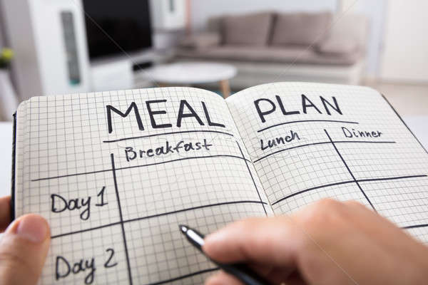 Stock photo: Human Hand Filling Meal Plan In Notebook