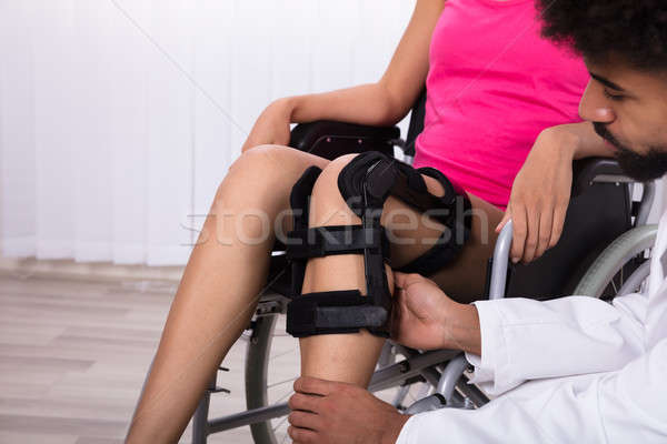 Physiotherapist Fixing Knee Braces On Woman's Leg Stock photo © AndreyPopov