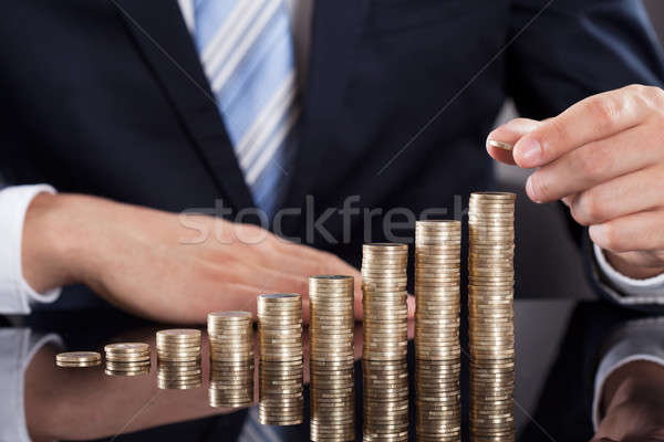 Businessman Stacking Coins At Desk Stock photo © AndreyPopov