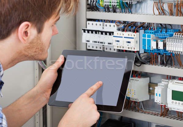 Technician Examining Fusebox Using Tablet Stock photo © AndreyPopov