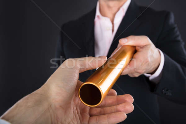 Businessman Passing A Golden Relay Baton Stock photo © AndreyPopov