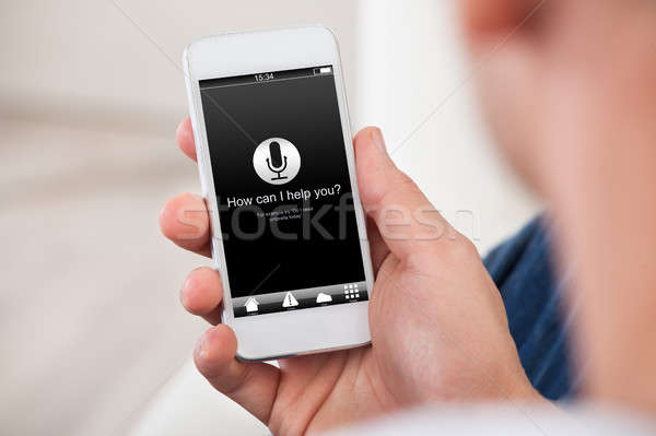 Man Holding Smart Phone With How Can I Help You? Stock photo © AndreyPopov