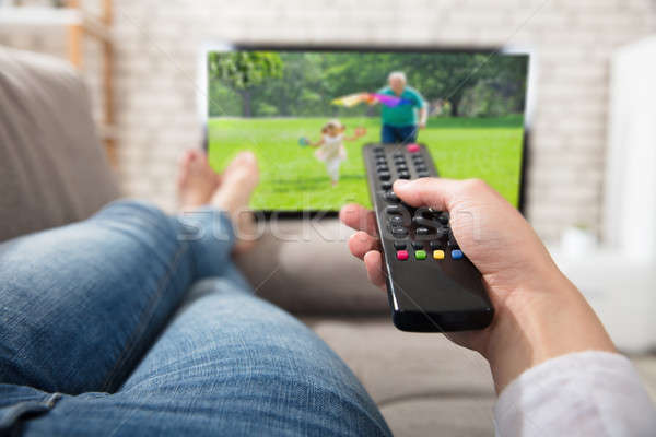 Woman Changing The Channel With Remote Control Stock photo © AndreyPopov