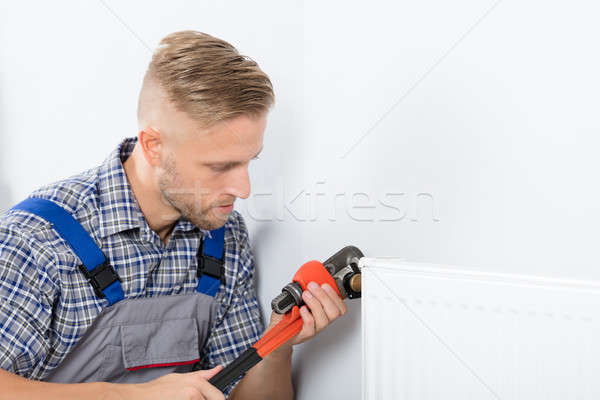 Férfi vízvezetékszerelő megjavít termosztát franciakulcs közelkép Stock fotó © AndreyPopov