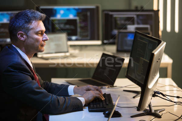 Zakenman werken meervoudig computers zijaanzicht volwassen Stockfoto © AndreyPopov