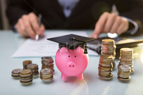 Close-up Of Piggy Bank Wearing Graduation Hat And Stacked Coins Stock photo © AndreyPopov