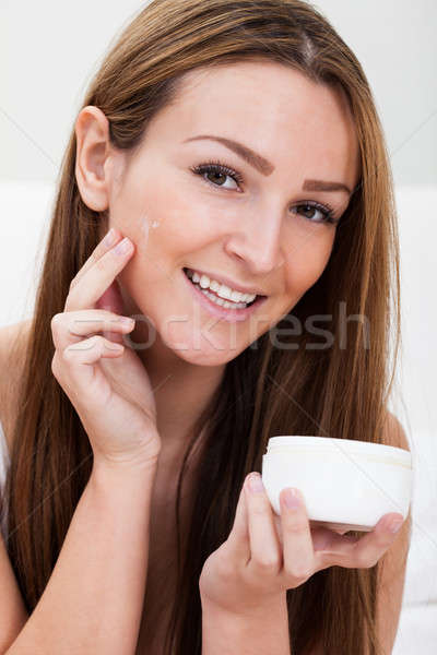 Young Woman Applying Cream Stock photo © AndreyPopov