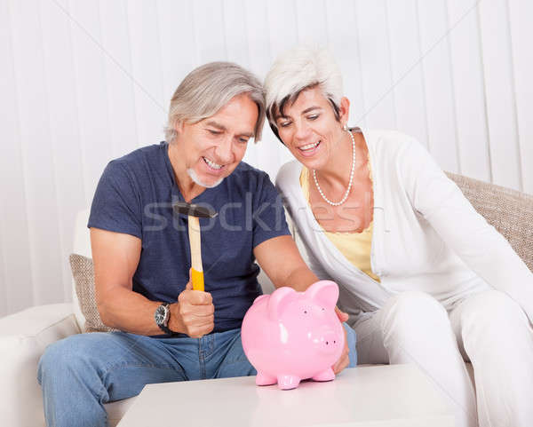 Senior couple raiding a piggybank Stock photo © AndreyPopov