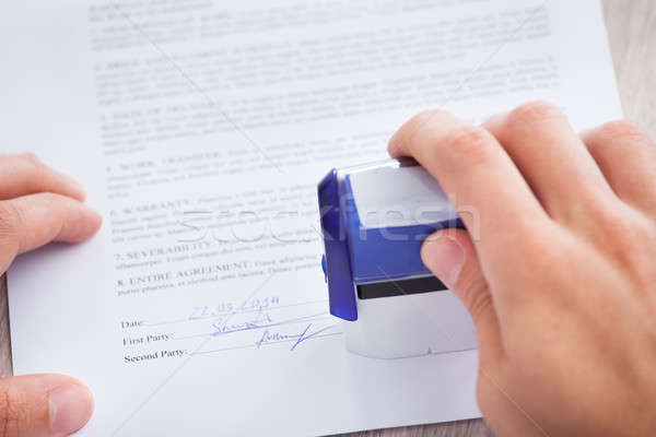 Businessman Stamping Contract Paper On Table Stock photo © AndreyPopov