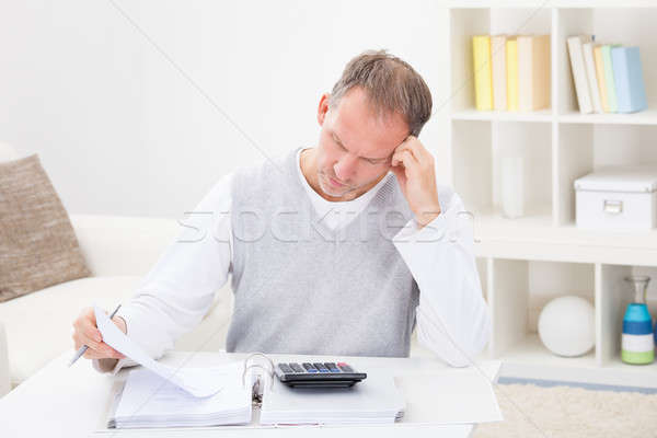 Thoughtful Man Holding Calculator Stock photo © AndreyPopov