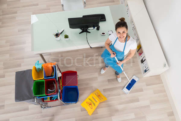 Young Female Janitor Mopping Wooden Floor Stock photo © AndreyPopov