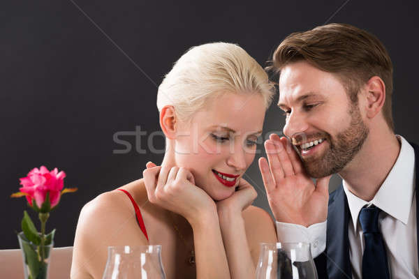 Man Whispering In Woman's Ear Stock photo © AndreyPopov