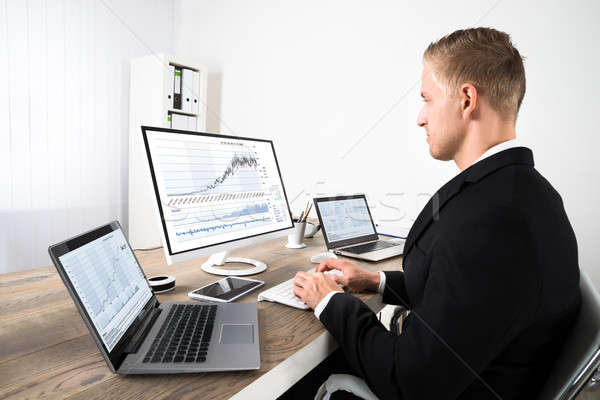 Stock Market Broker Looking At Graphs In Office Stock photo © AndreyPopov