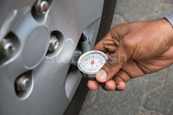 Person Holding Gauge For Measuring Tyre Pressure Stock photo © AndreyPopov