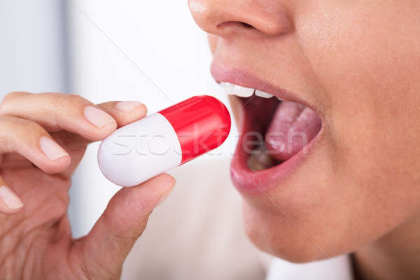 Nő elvesz túlméretezett gyógyszer tabletta közelkép Stock fotó © AndreyPopov