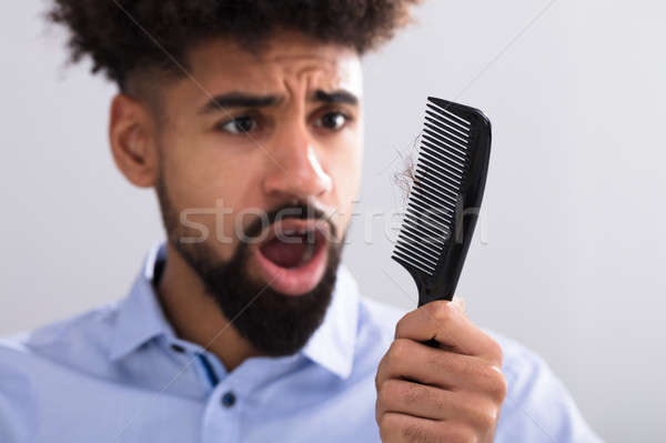 Man Looking At Hair Loss Stock photo © AndreyPopov
