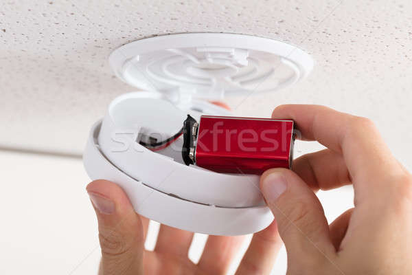 Person's Hand Inserting Battery In Smoke Detector Stock photo © AndreyPopov
