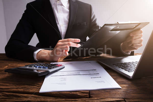 Businessperson Analyzing Document On Clipboard Stock photo © AndreyPopov