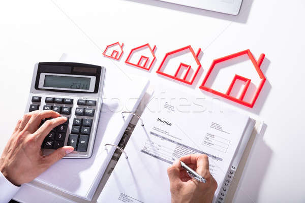 Businessperson Calculating Bill With Calculator Stock photo © AndreyPopov