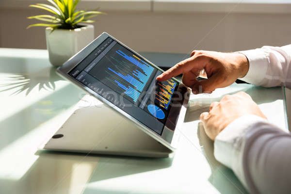 Businessman analyzing graph on laptop Stock photo © AndreyPopov