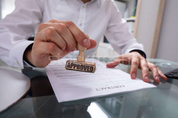 Stock photo: Businessman Stamping Approved On Contract Paper