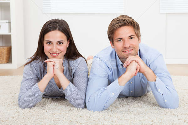 Happy Couple Lying On Rug In Living Room Stock photo © AndreyPopov