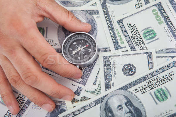 Hand Holding Compass On Us Currency Stock photo © AndreyPopov
