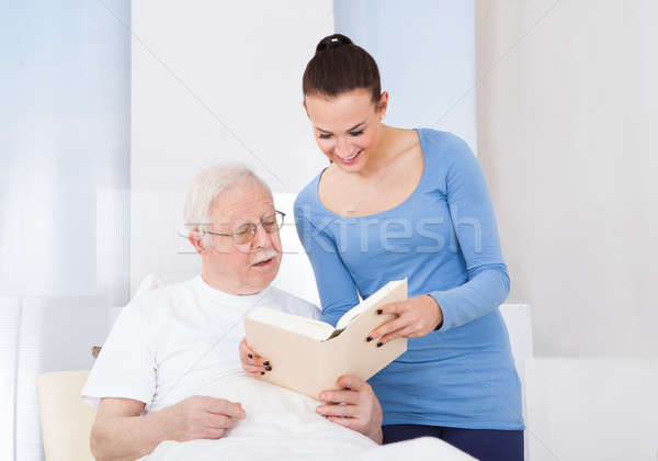 Caretaker And Senior Man Reading Book Stock photo © AndreyPopov