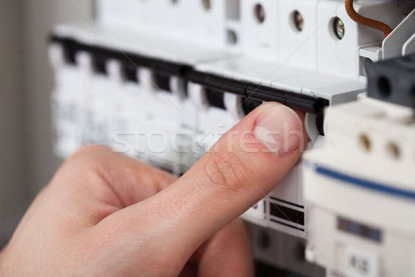 Technician Turning On Switch In Fusebox Stock photo © AndreyPopov