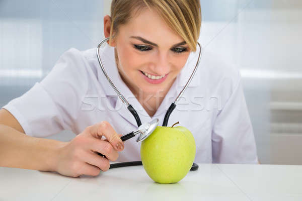 Female Dietician Examining Green Apple Stock photo © AndreyPopov