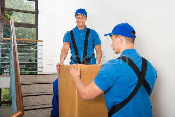 Two Movers Standing With Box On Staircase Stock photo © AndreyPopov